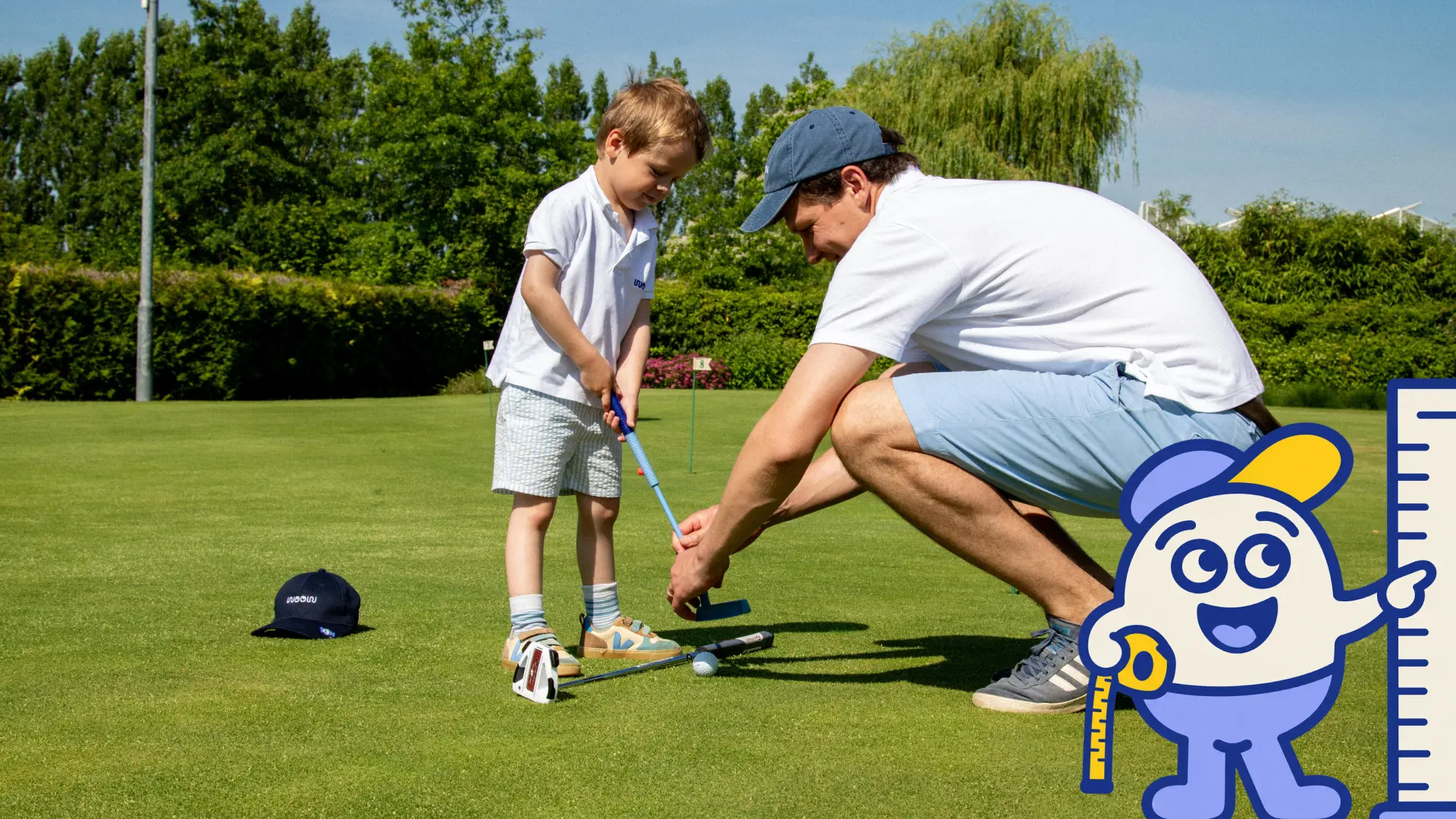 A parent helping a young child set up with a golf club on a putting green