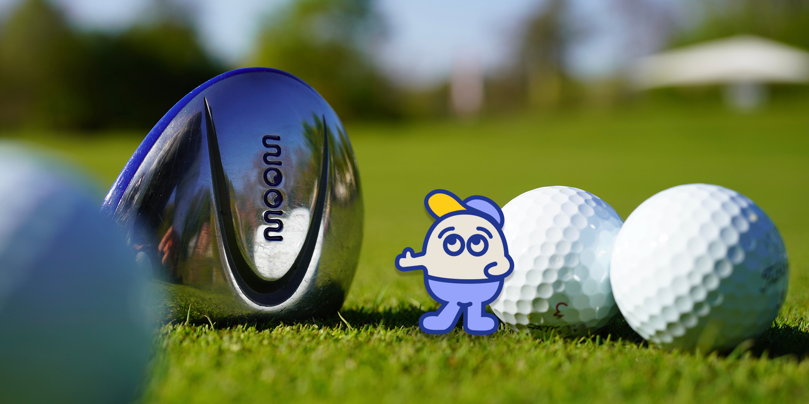 A WOOW kids golf club head next to golf balls and the Archie mascot on grass